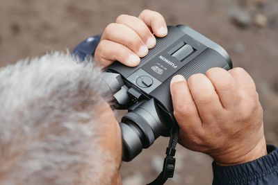 An overhead shot of a person using Fujifilm’s new stabilized binoculars.